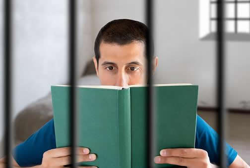 boy reading a book in jail